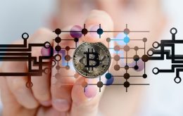 Kryptowährungen - Hand mit Bitcoint in der Hand